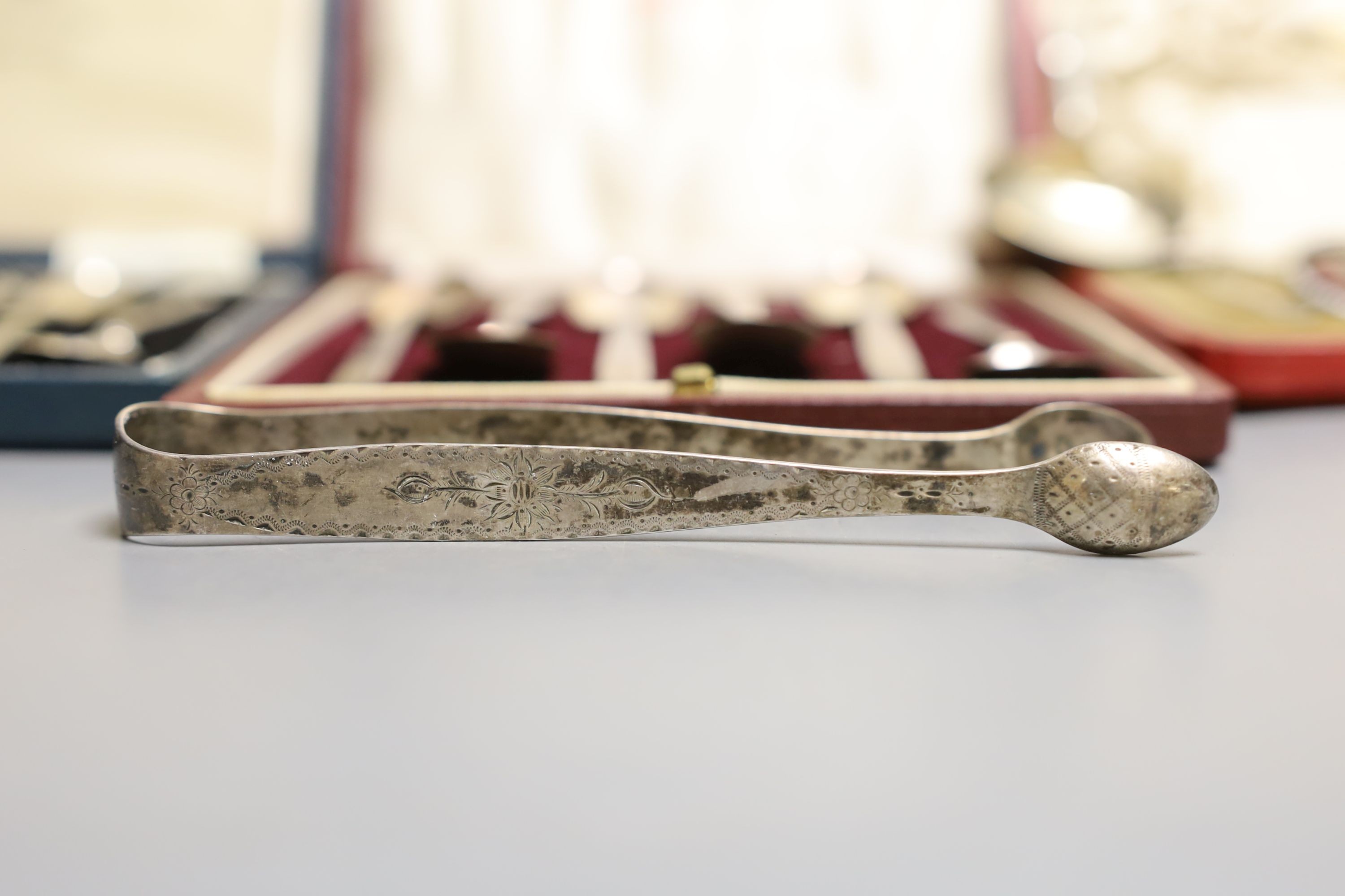 Two cased sets of six silver teaspoons including Art Deco and a cased set of Scandinavian gilt white metal and enamel coffee spoons(a.f.0, a silver sugar caster, pair of silver tongs and a Georgian silver caddy spoon.